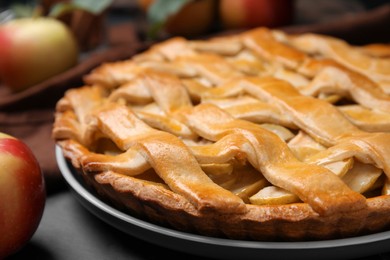 Delicious traditional apple pie on black table, closeup