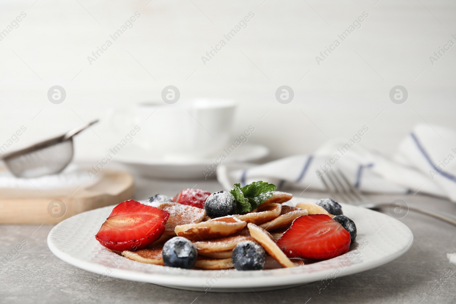 Photo of Cereal pancakes with berries on light grey table