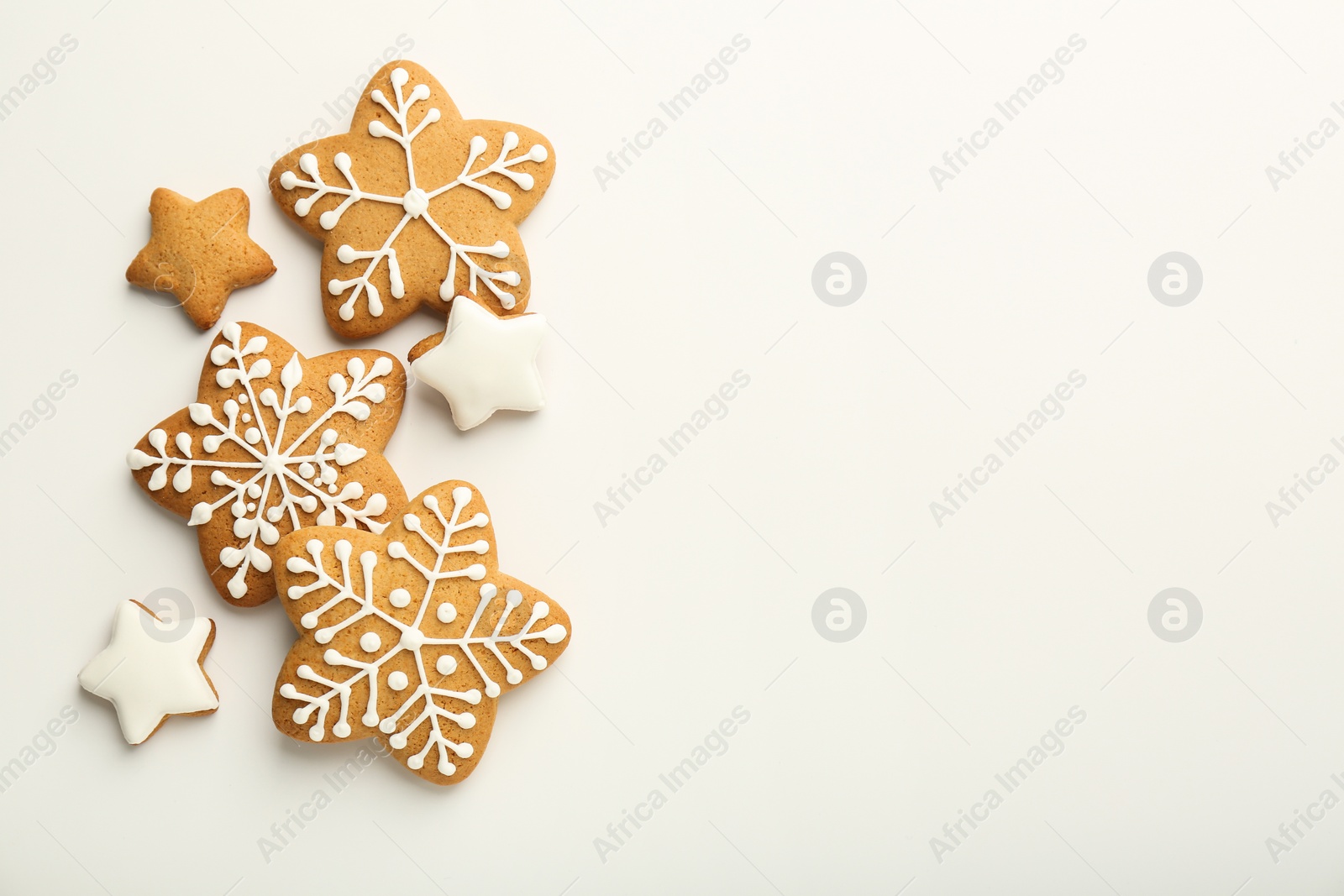 Photo of Tasty Christmas cookies with icing on white background, flat lay. Space for text