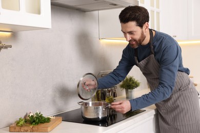 Man cooking soup on cooktop in kitchen