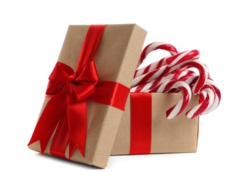 Photo of Christmas gift box with candy canes on white background