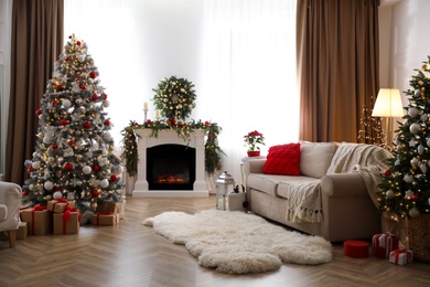 Photo of Festive living room interior with Christmas trees and fireplace