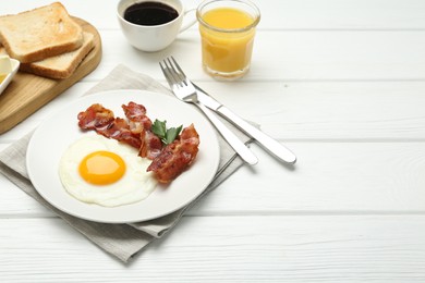 Photo of Delicious breakfast with sunny side up egg served on white wooden table. Space for text