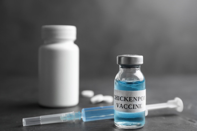 Photo of Chickenpox vaccine and syringe on grey background. Varicella virus prevention