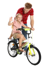 Young father teaching daughter to ride bicycle on white background