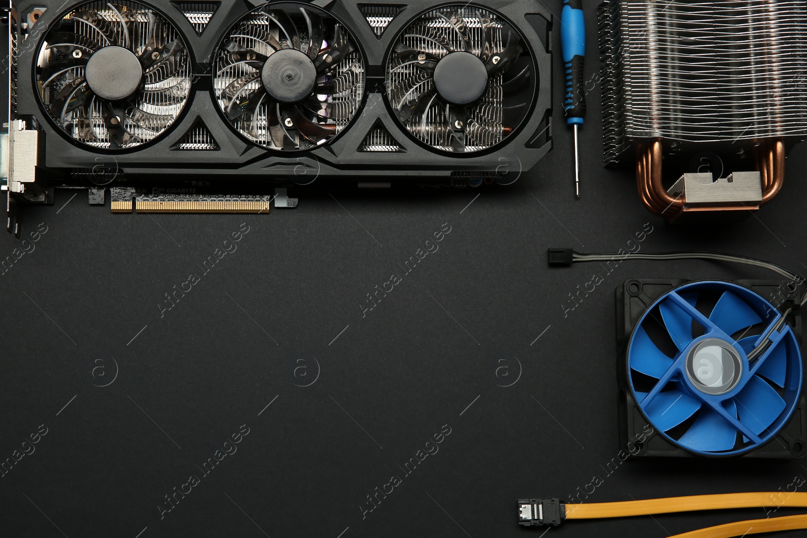 Photo of Graphics card and other computer hardware on black background, flat lay. Space for text