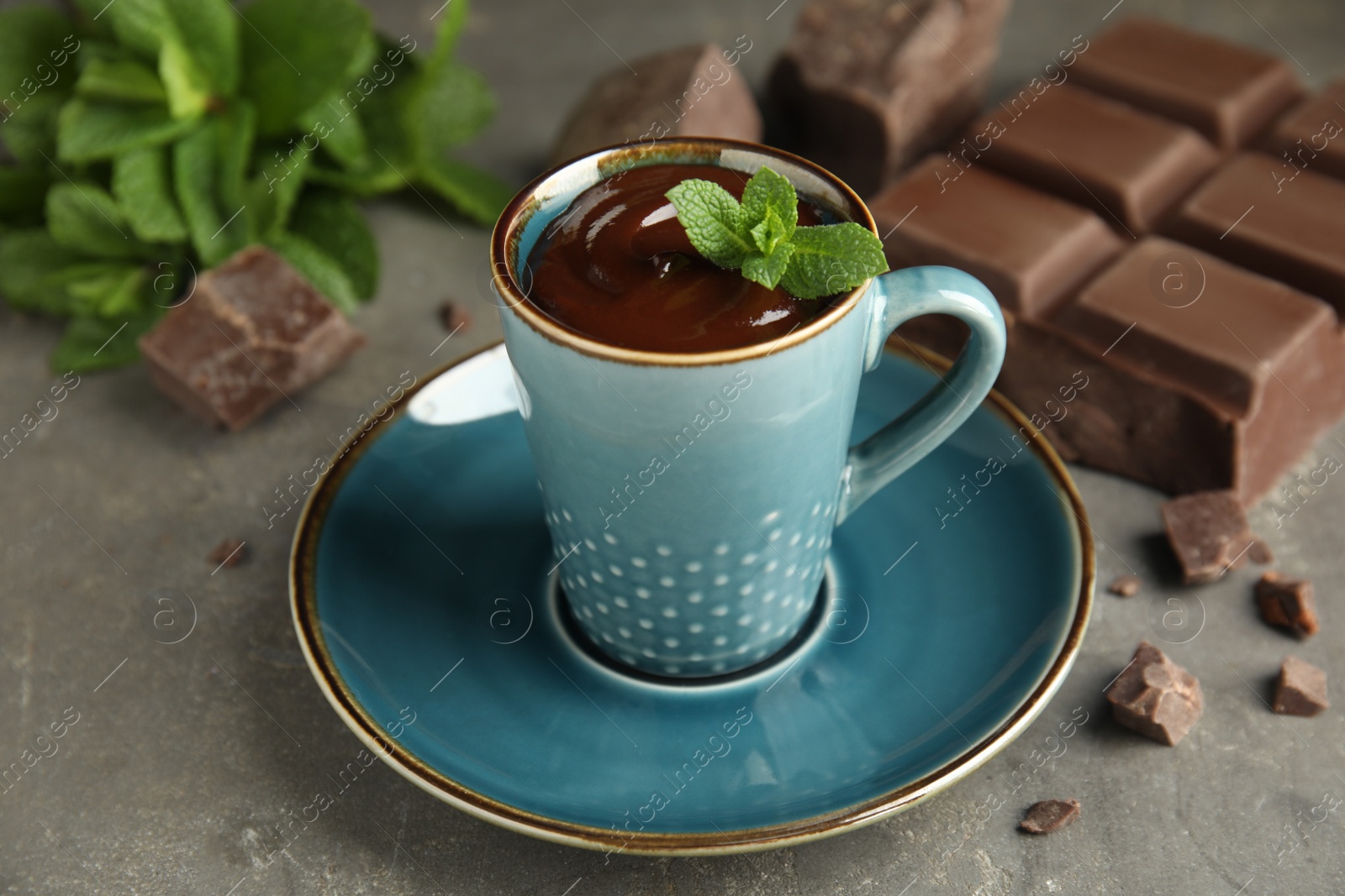 Photo of Cup of delicious hot chocolate with fresh mint on grey table