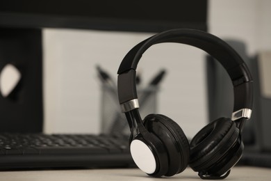 Photo of Modern headphones and computer on table indoors, space for text