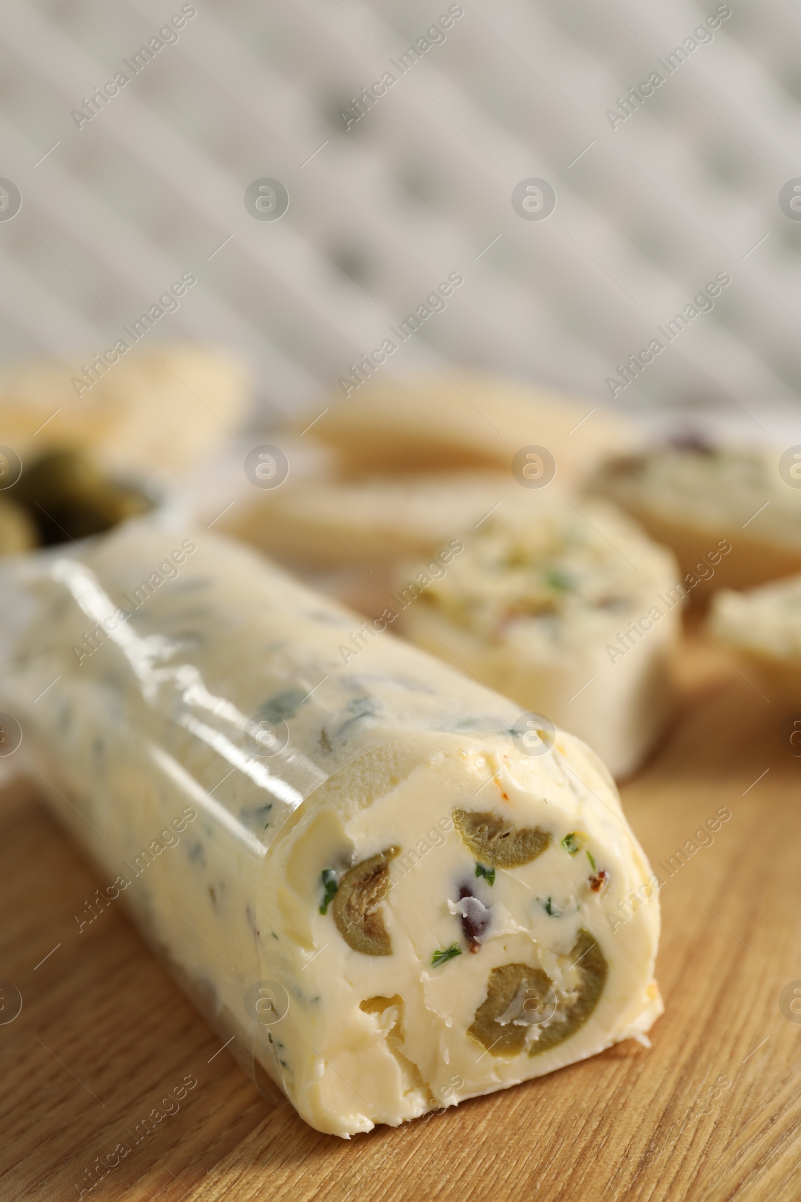 Photo of Tasty butter with olives and green onion on wooden table, closeup