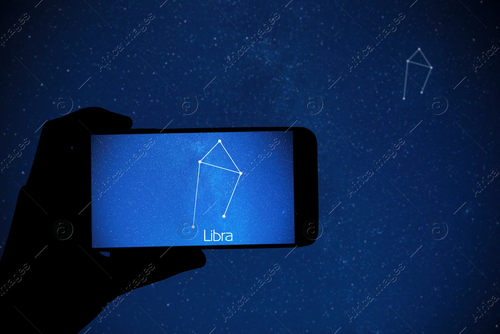 Image of Woman using stargazing app on her phone at night, closeup. Identified stick figure pattern of Libra constellation on device screen