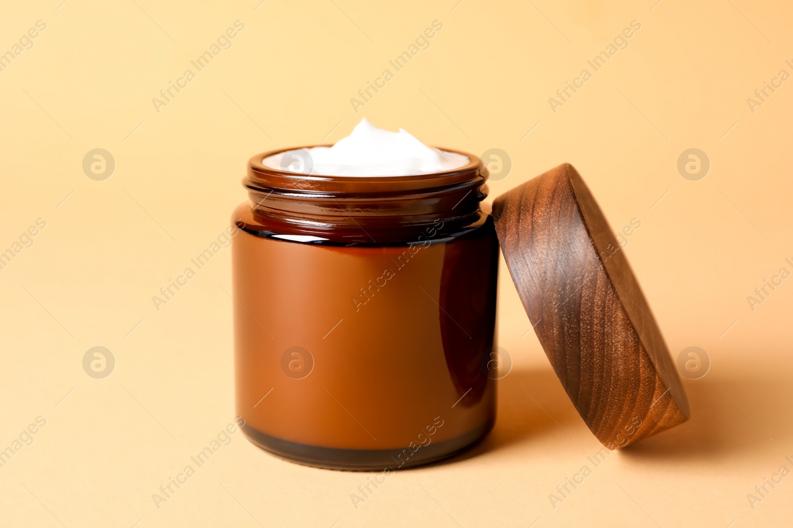 Photo of Jar of face cream on light orange background