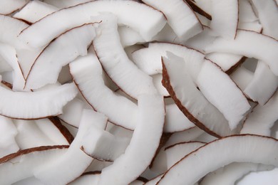 Fresh coconut pieces as background, top view