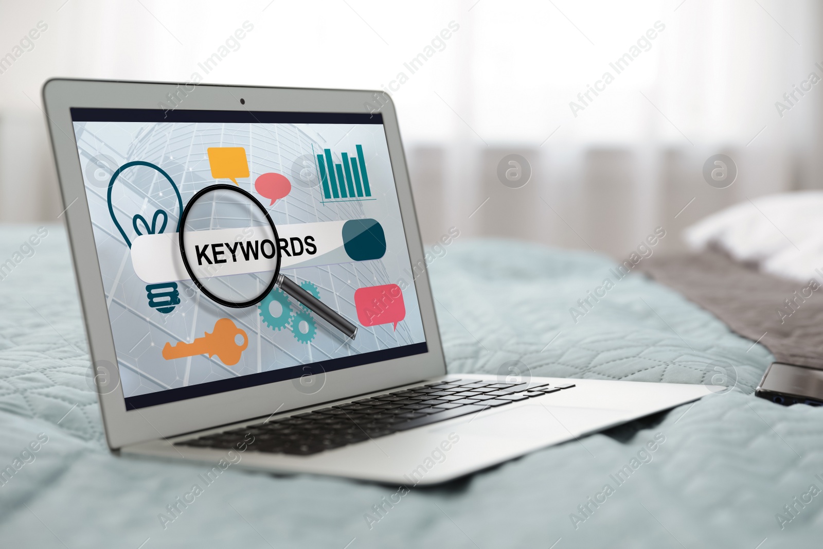 Image of Keywords research concept. Modern laptop with search bar and icons on bed indoors