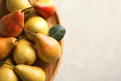 Photo of Plate with ripe pears on light background, closeup. Space for text