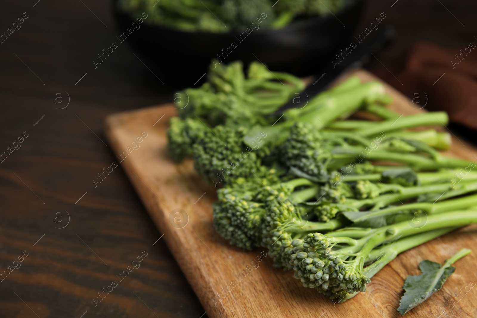 Photo of Fresh raw broccolini on wooden table, closeup and space for text. Healthy food