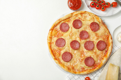 Photo of Flat lay composition with tasty pepperoni pizza on white table. Space for text