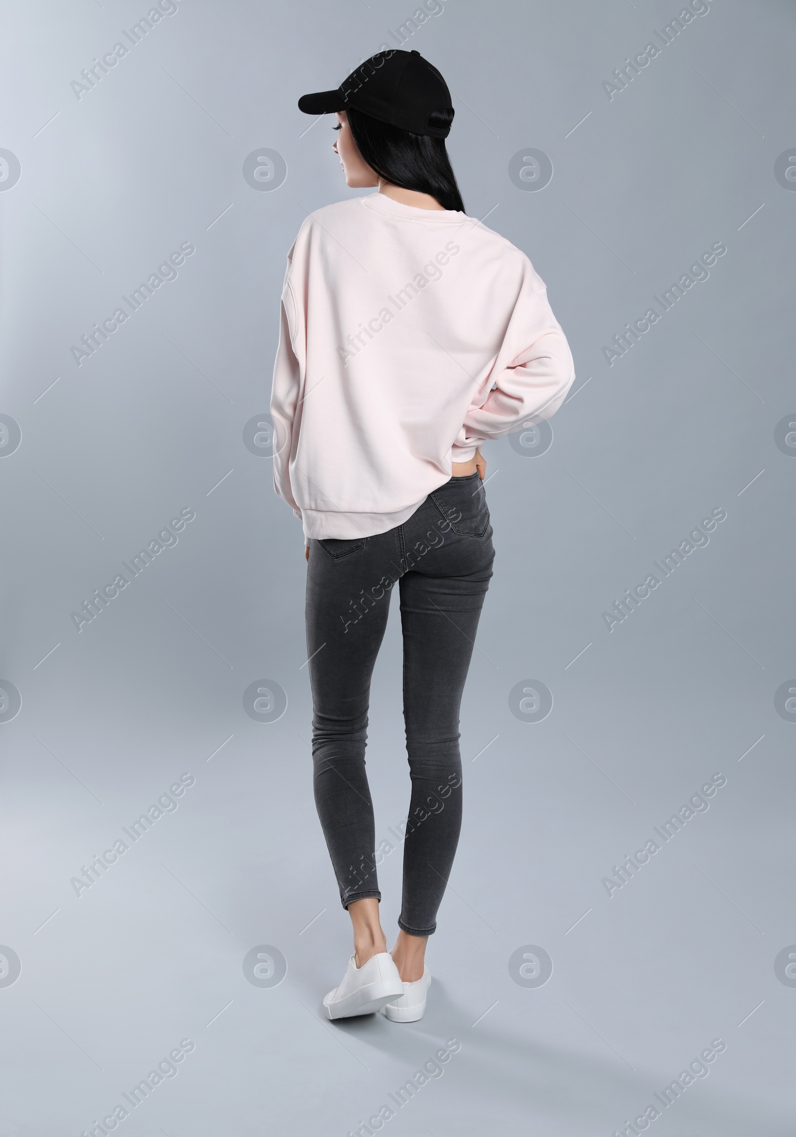 Photo of Young woman in sweater on grey background. Mock up for design