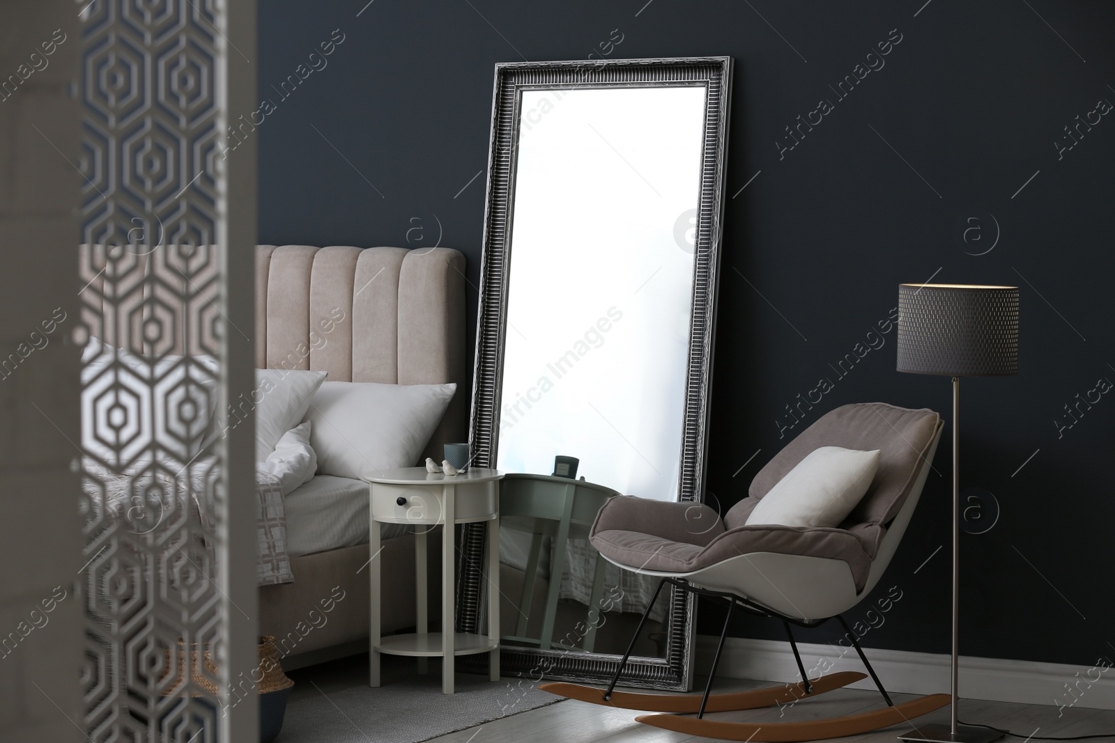 Photo of Elegant mirror near bed in stylish room interior