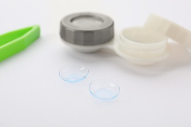 Contact lenses, case and tweezers on white background, closeup