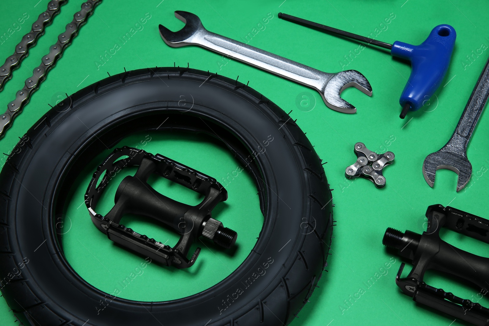 Photo of Set of different bicycle tools and parts on green background