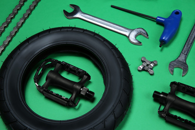 Set of different bicycle tools and parts on green background