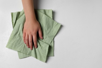 Photo of Woman cleaning light table with paper towel, top view. Space for text