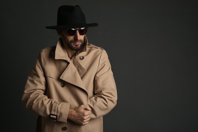 Photo of Exhibitionist in coat and hat on black background. Space for text