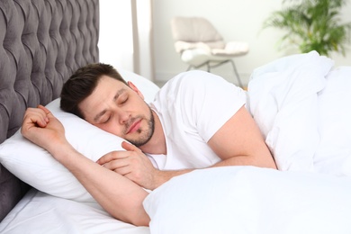 Photo of Handsome man sleeping on pillow at home. Bedtime