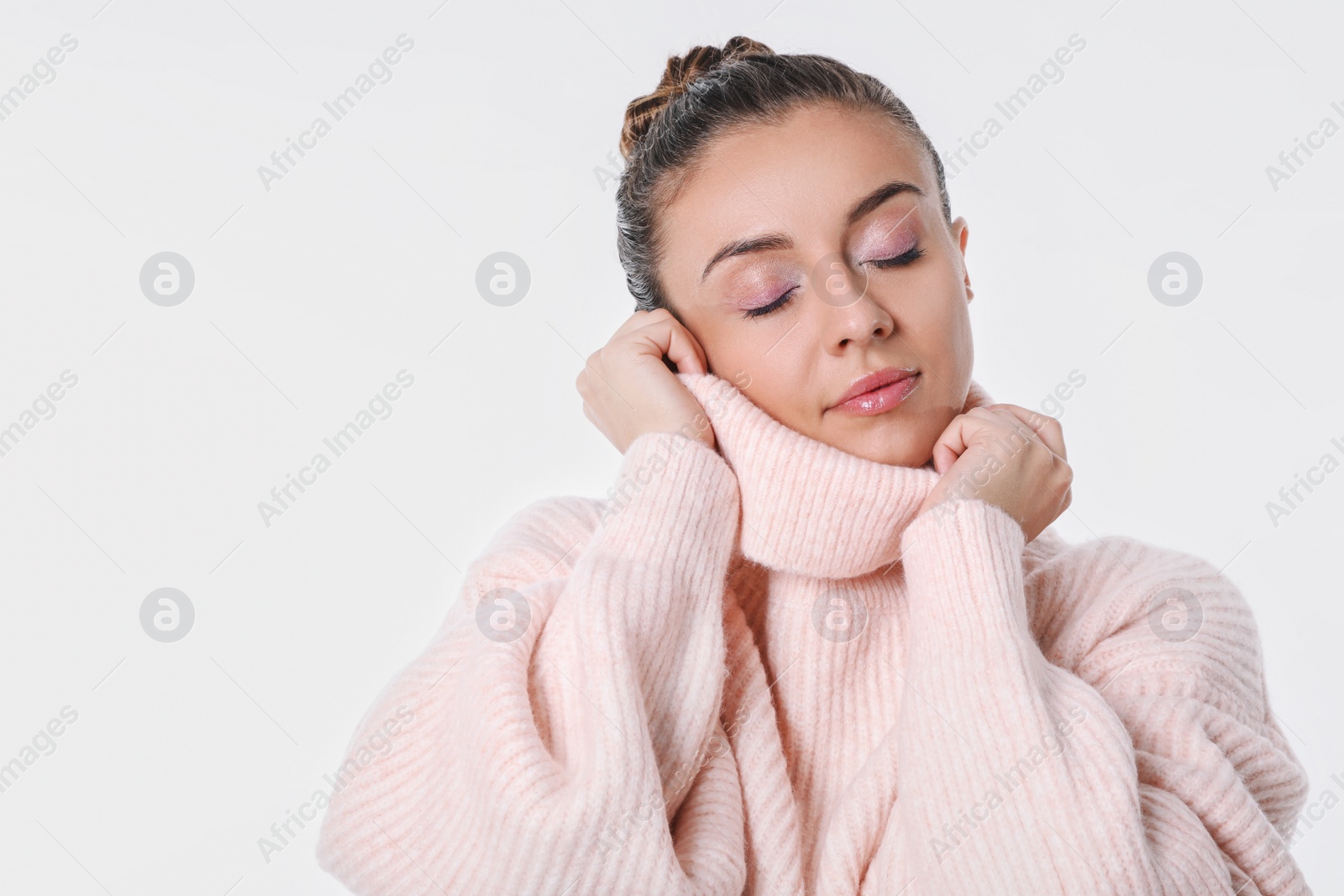 Photo of Young woman in stylish pink sweater on white background