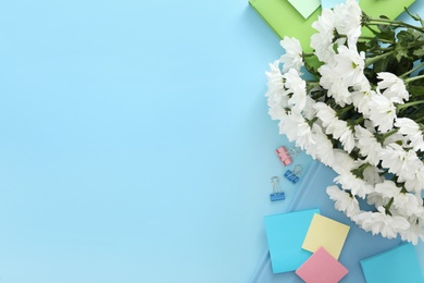 Photo of Beautiful flowers and stationery on light blue background, flat lay with space for text. Teacher's Day