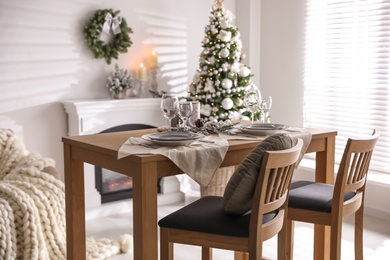 Photo of Festive table setting and beautiful Christmas decor in living room. Interior design