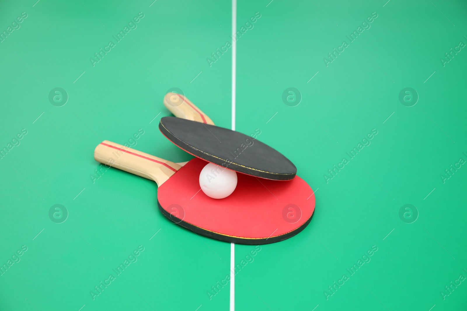 Photo of Tennis rackets and ball on ping pong table