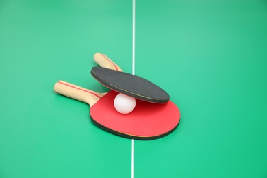 Tennis rackets and ball on ping pong table