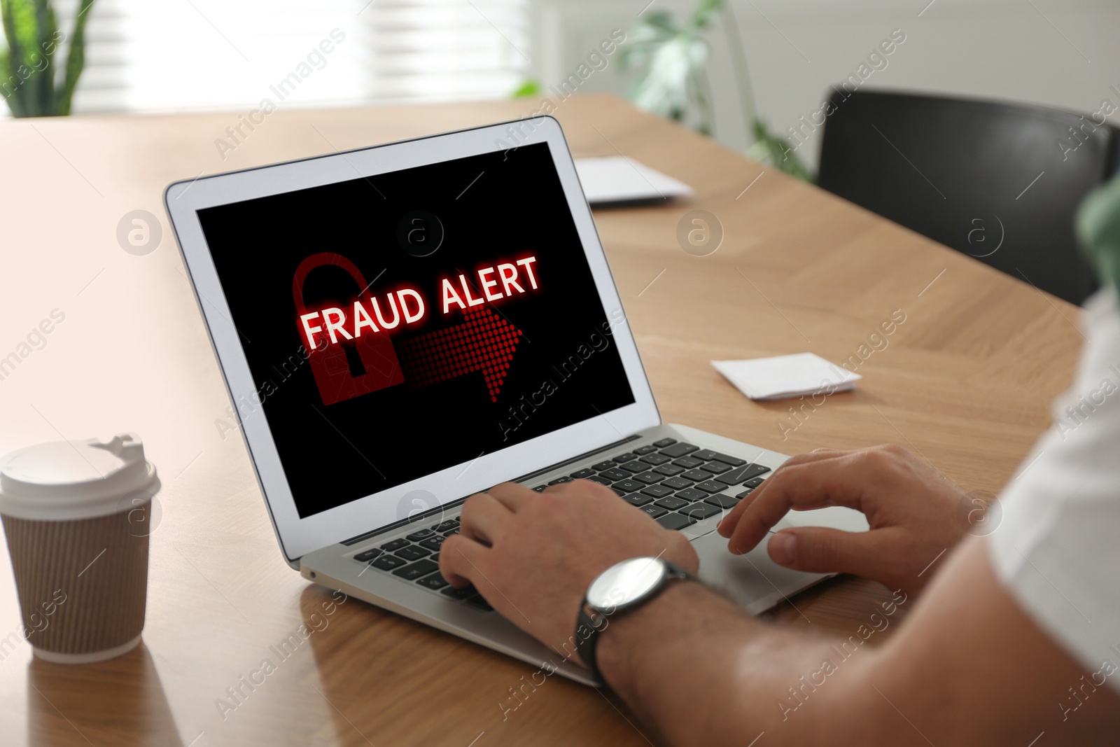 Image of Fraud prevention security system. Man using laptop at wooden table, closeup