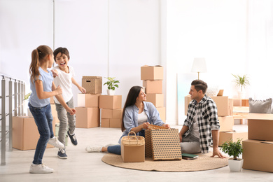 Photo of Happy family unpacking moving boxes at their new home