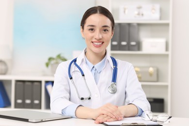 Photo of Medical consultant with stethoscope at table in clinic