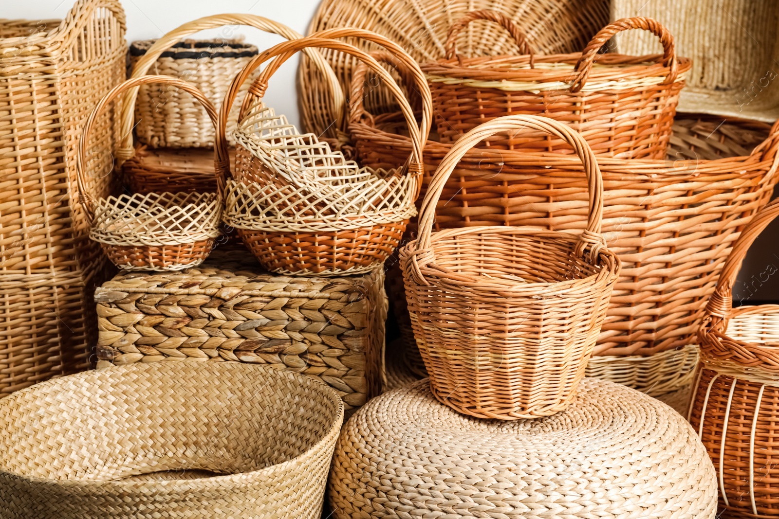 Photo of Many different wicker baskets made of natural material as background, closeup