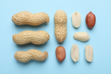 Fresh peanuts on light blue background, flat lay