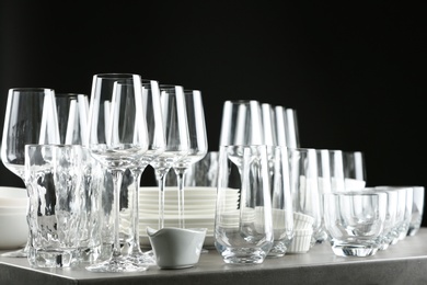 Photo of Set of empty glasses and dishware on table against black background