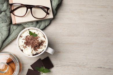 Cup of delicious hot chocolate with whipped cream and mint on white wooden table, flat lay. Space for text