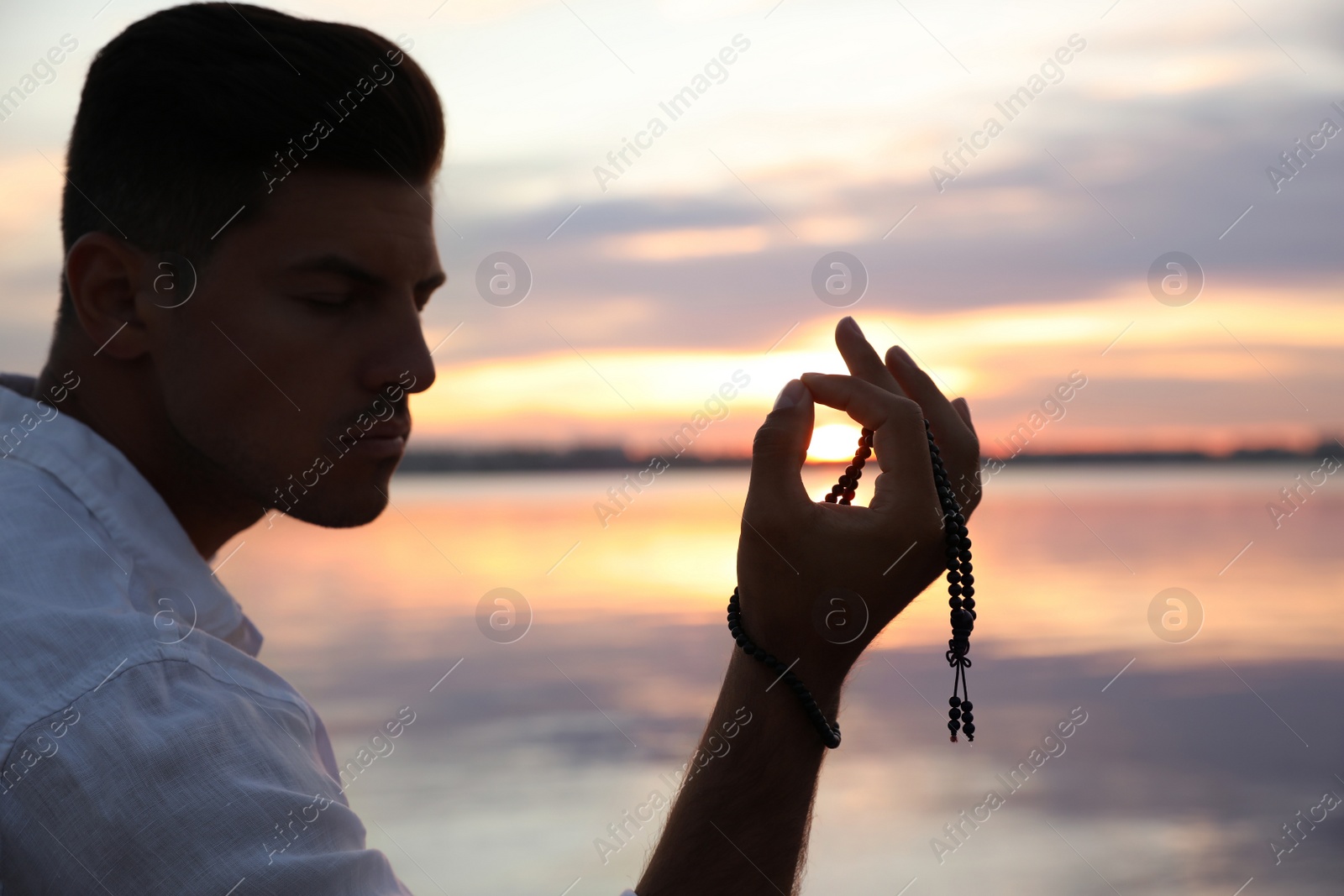 Photo of Man near river at sunset. Nature healing power