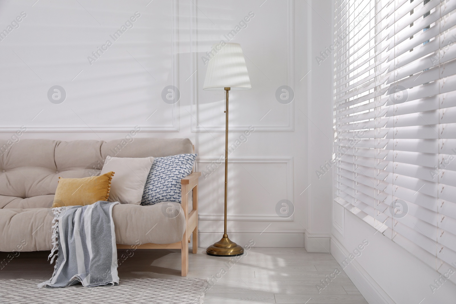 Photo of Interior of living room with comfortable sofa and floor lamp