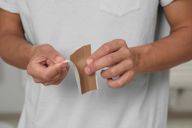 Photo of Man with sticking plaster indoors, closeup view