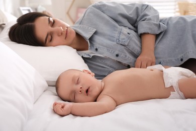 Photo of Mother with her cute baby sleeping on bed at home