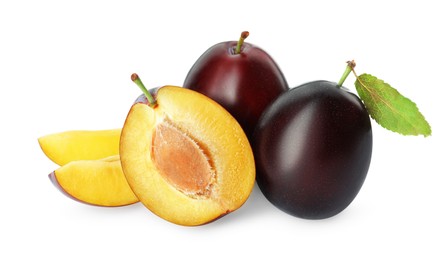 Whole and cut ripe plums on white background
