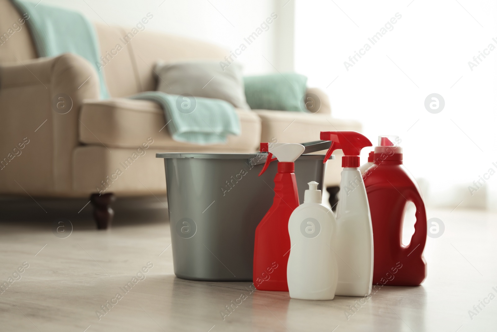 Photo of Bucket and different cleaning supplies on floor indoors