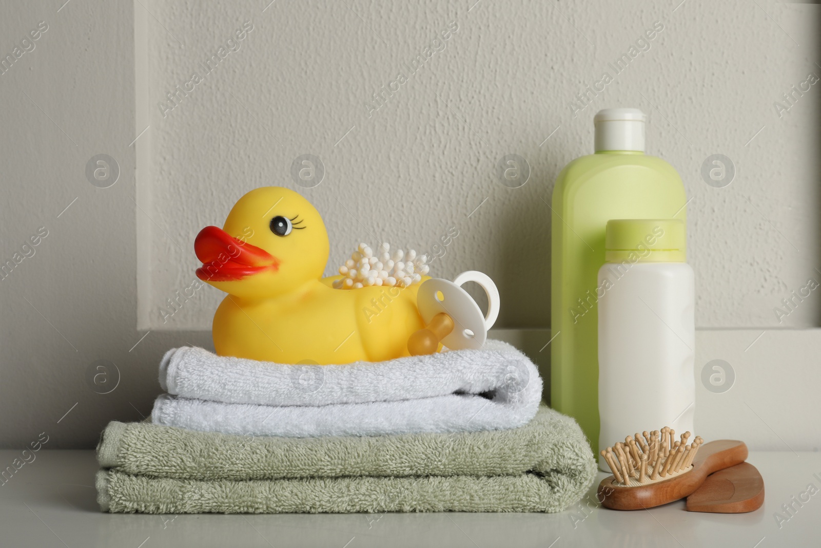 Photo of Bathroom towels, toy and baby accessories on white table