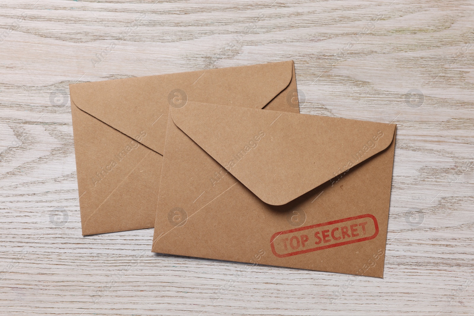 Image of Top Secret stamp. Paper envelopes on wooden table, top view