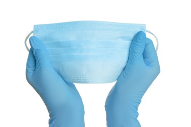 Photo of Doctor in latex gloves holding medical mask on white background, closeup