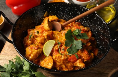 Delicious chicken curry in frying pan on table, closeup